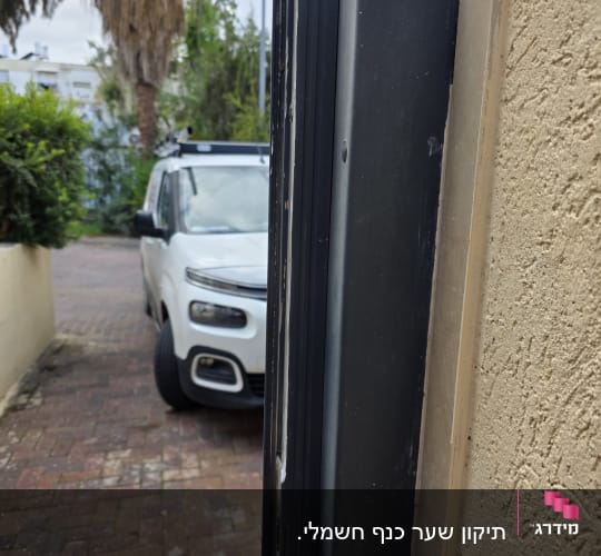 שער חשמלי עם רכב חונה ברקע